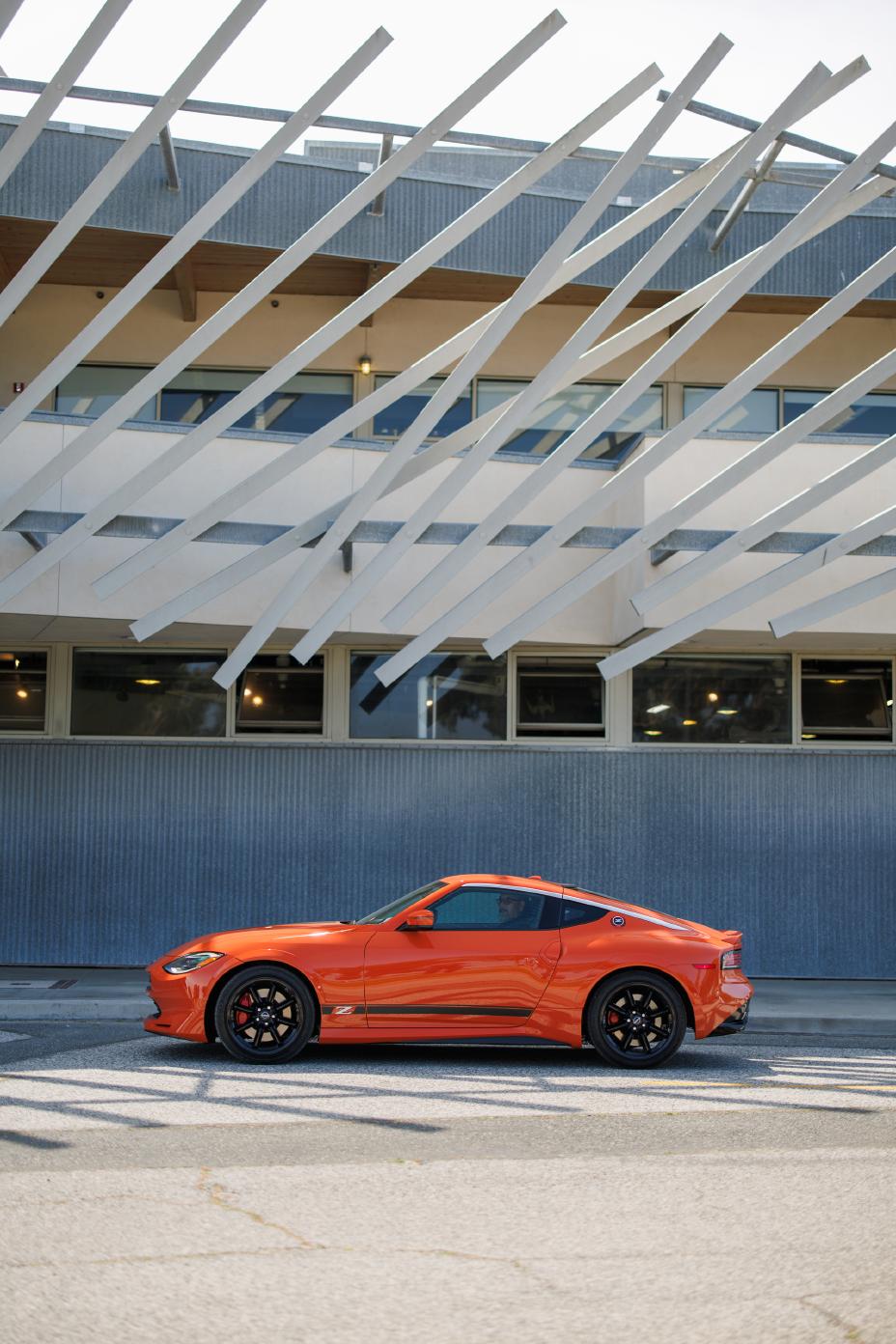 Profile of orange Z Nissan Heritage Edition with a building in the background