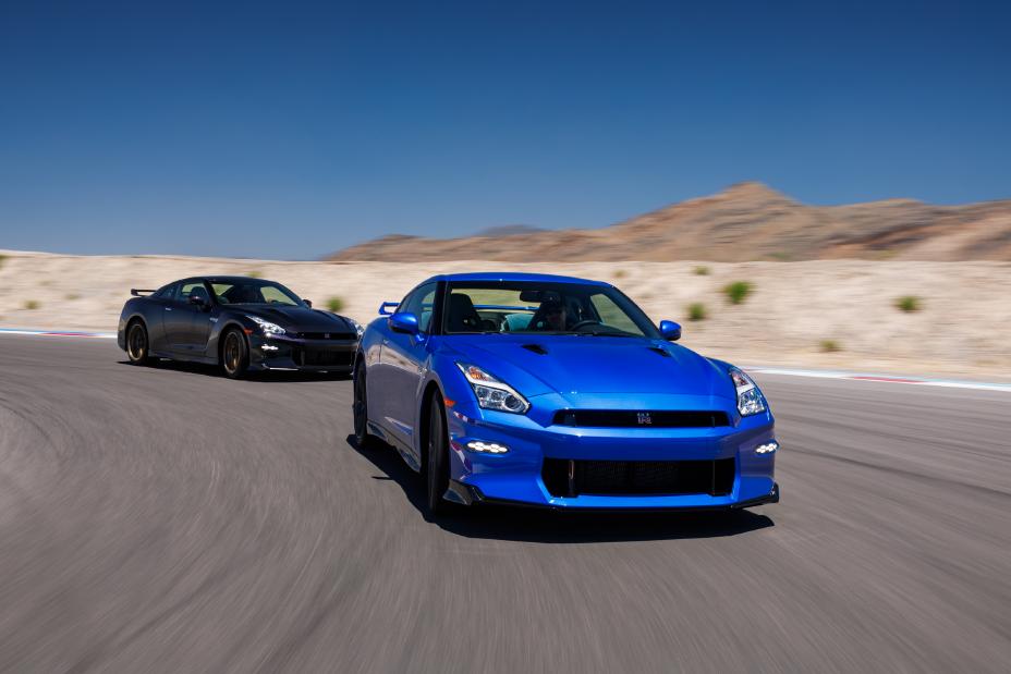 Two Nissan 2024 GT-R Special Editions driving around a corner on a race track with mountains in the background
