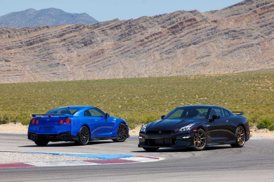 Two 2024 GT-R Special Editions, blue on left and black on right, on a track with a mountain in the background