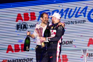 Oliver Rowland and Tommaso Volpe arm in arm on the London E-Prix podium, celebrating victory