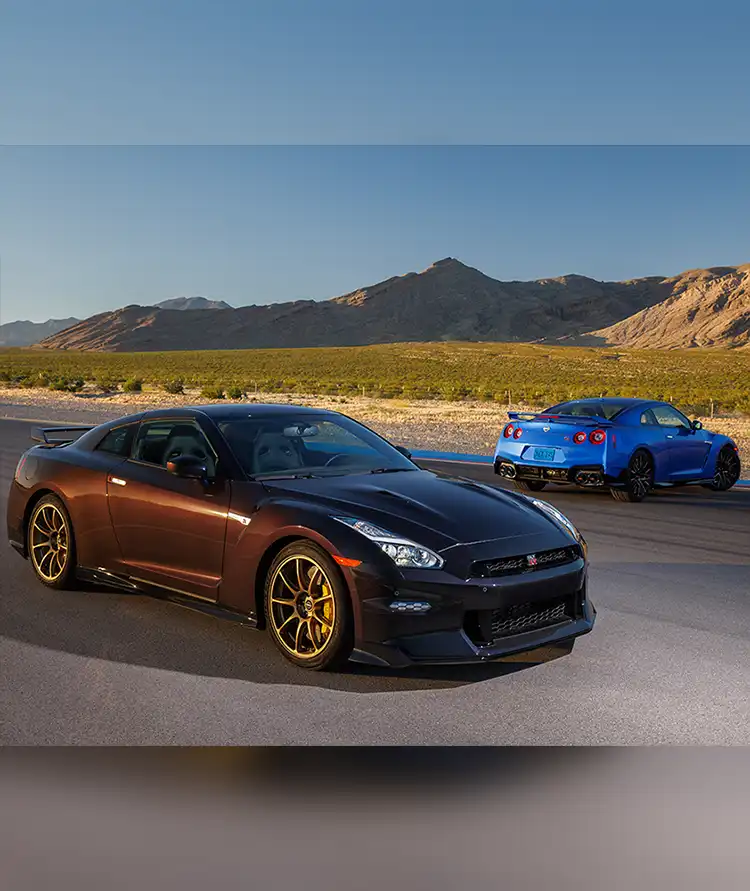 Two 2024 GT-R Special Editions on a race track with a mountain in the background