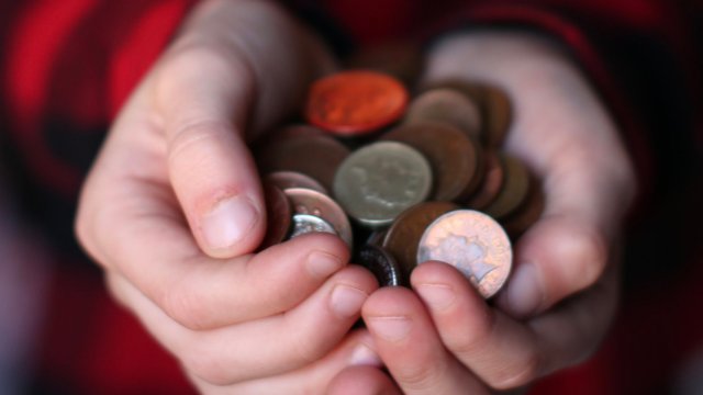 Article thumbnail: Boy cups his hands filled with coins.