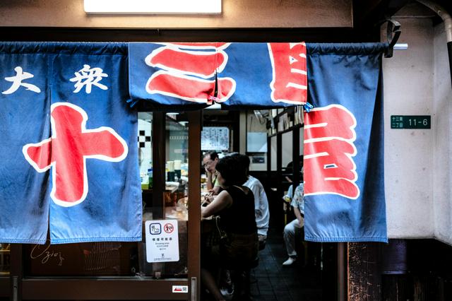 青いのれんの奥は酔客でにぎわう=中田浩資撮影