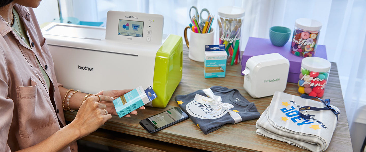 Person sitting in craft room P-touch Embellish label maker and Brother ScanNCut electronic cutting machine