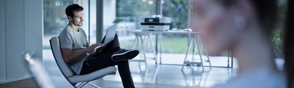 Man and woman using devices while sitting in a home office environment