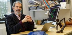 Michele Vendruscolo at his desk. A molecule is on the computer screen.