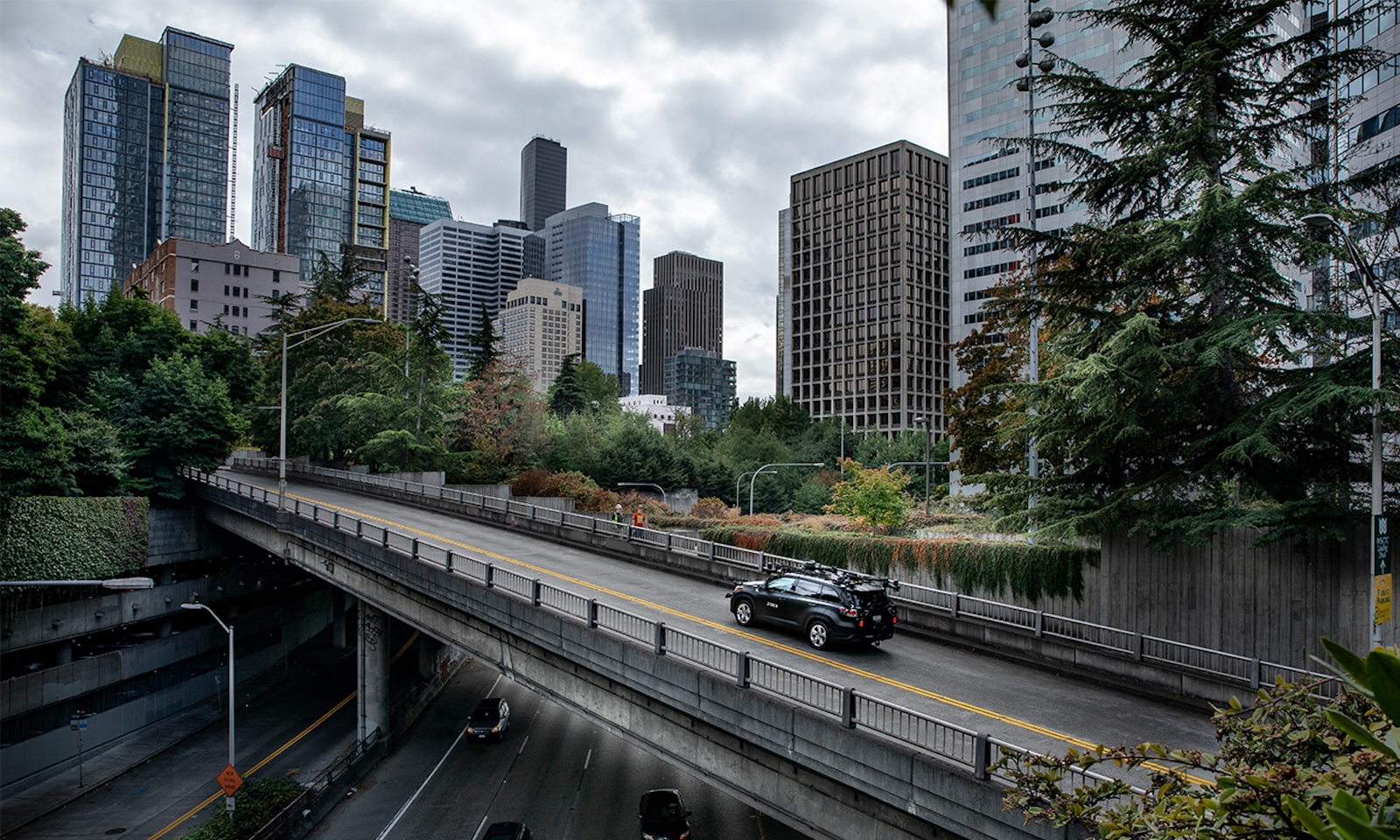 zoox test vehicle driving across a bridge in seattle on a rainy day