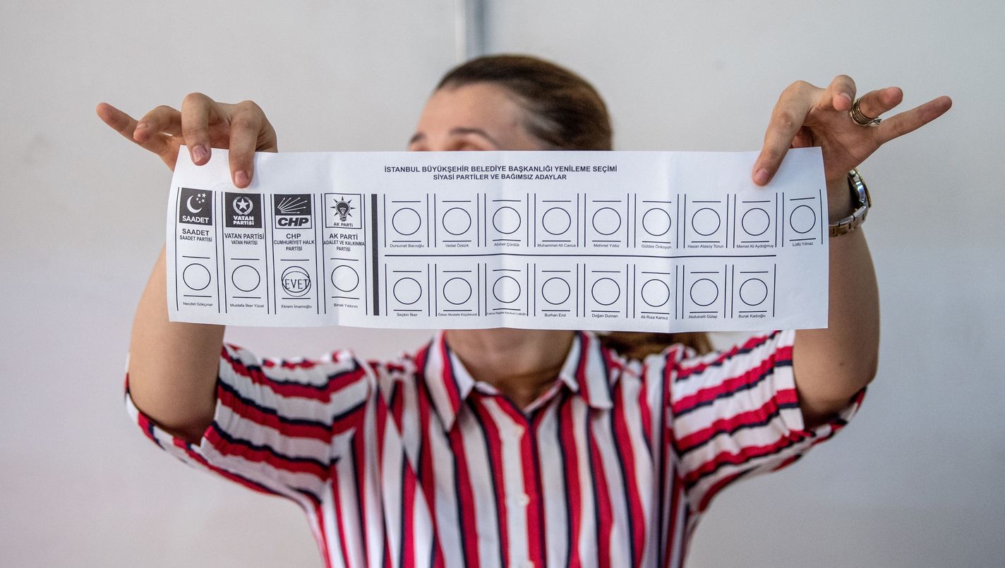 A woman displays a ballot paper as election officials count votes in a mayoral re-run at a polling station in Istanbul, on June 23, 2019. - Polls closed on June 23, in a replay of the mayoral election in Istanbul, with voters anxiously awaiting a verdict seen as crucial to the future of Turkish democracy and its long-ruling president, Recep Tayyip Erdogan. Republican People's Party (CHP) Ekrem Imamoglu was a little-known district mayor who caused a huge upset when he narrowly beat the ruling  Justice and Development Party's (AKP) candidate Binali Yildirim in March. Election authorities annulled that result after the Turkish President claimed irregularities in the counting. (Photo by Bulent Kilic / AFP)        (Photo credit should read BULENT KILIC/AFP via Getty Images)