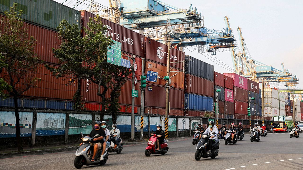 Motorists commute past shipping containers at the port in Keelung on September 17, 2022. (Photo by I-HWA CHENG / AFP) (Photo by I-HWA CHENG/AFP via Getty Images)