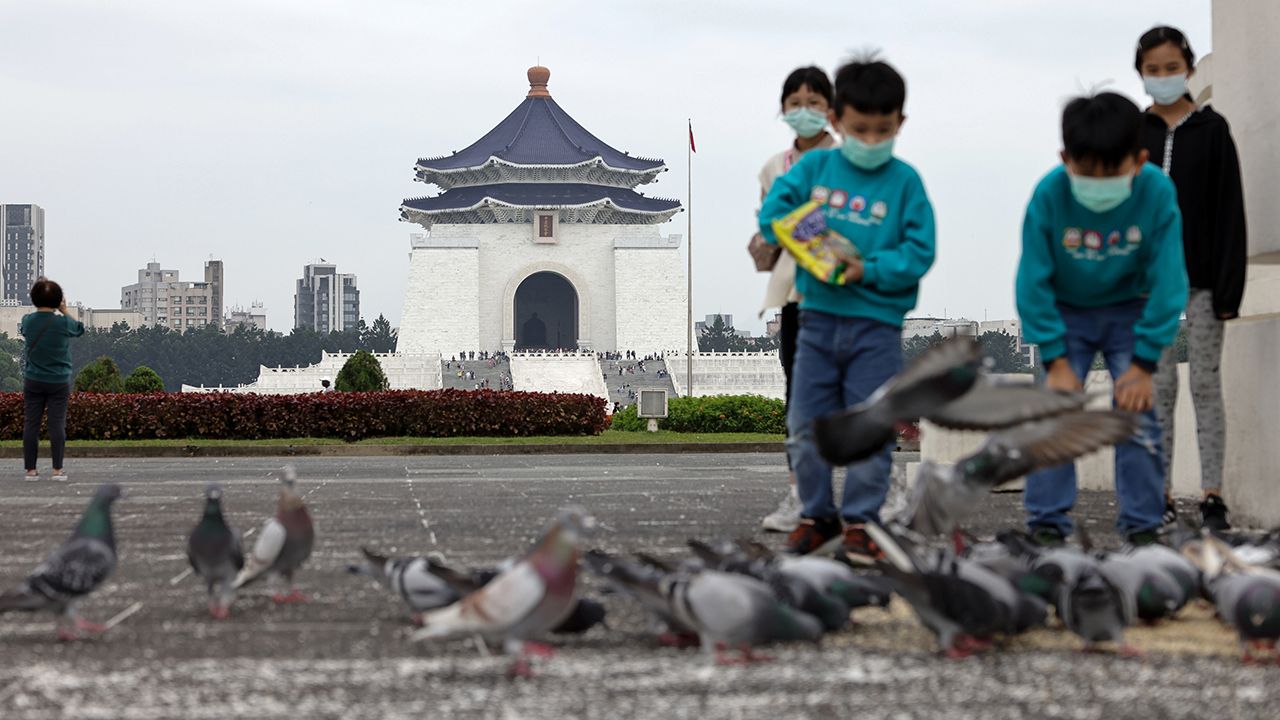 Children play with pigeons at Chiang Kai-shek Memorial Hall, in Taipei, Taiwan, February 15, 2023