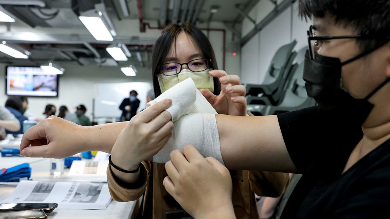 A participant practices using bandage during the basis camps at KUMA Academy in Taipei, Taiwan, February 18, 2023