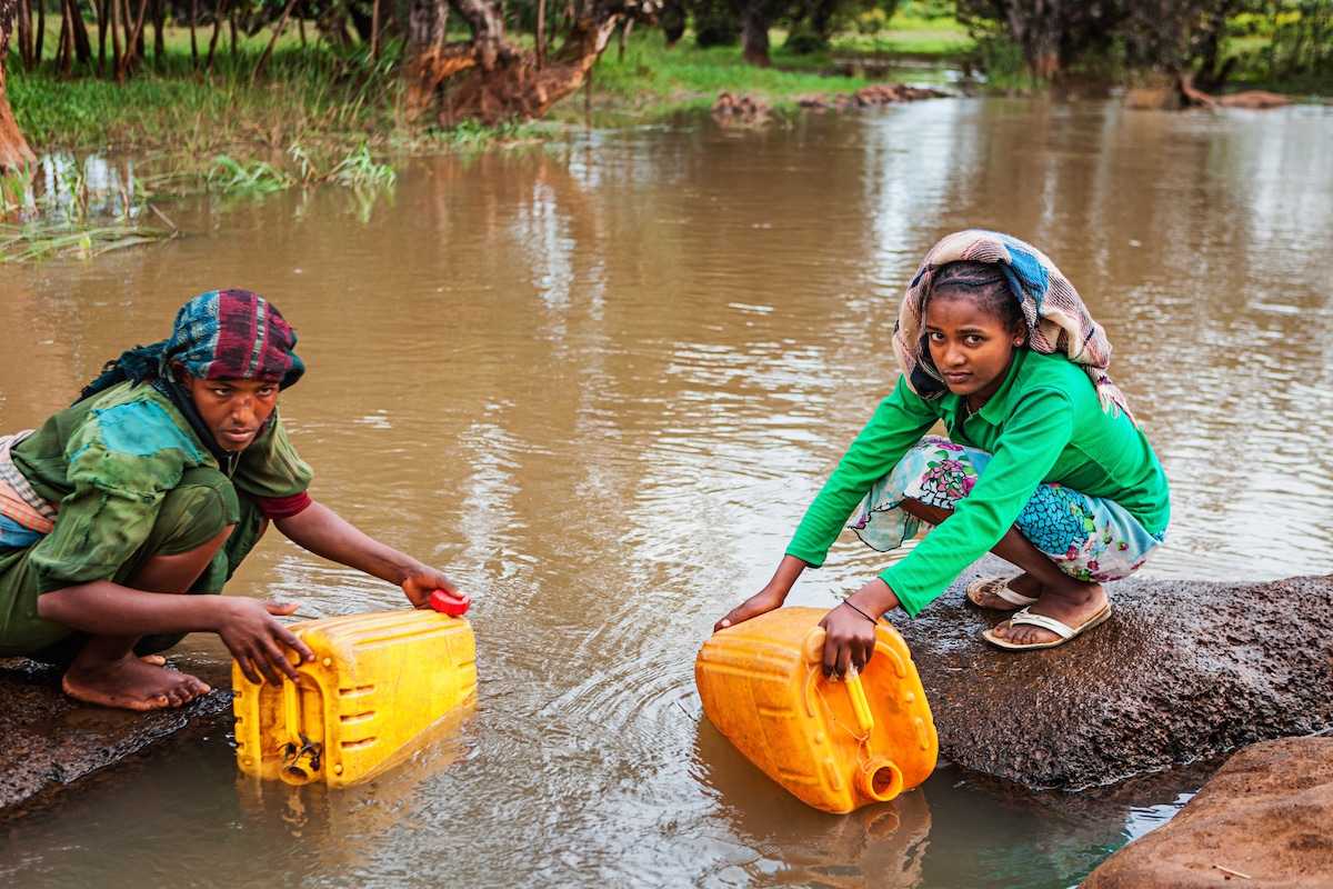 African women collect water from a river in Ethiopia