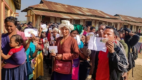 People from the Mizoram's Bru community, who resettled in Tripura, show their identification cards as they wait in queues to cast their votes at a polling booth during the Tripura Assembly elections. The migrants exercised their right to vote for the first time in the State. (PTI)