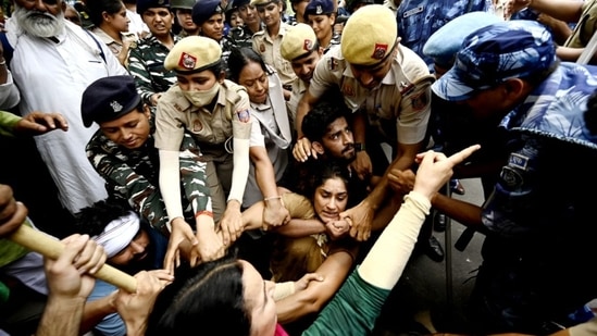 Ace wrestlers Vinesh Phogat, Sakshi Mallik and Bajrang Punia were among others who were detained by Delhi Police on Sunday while attempting to march to the new Parliament building where they planned to stage a demonstration.(Sanjeev Verma/ Hindustan Times)