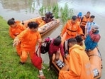 This undated photograph provided by National Disaster Response Force (NDRF) shows NDRF personnel rescuing flood affected people in north eastern Assam state. (NDRF via AP)
