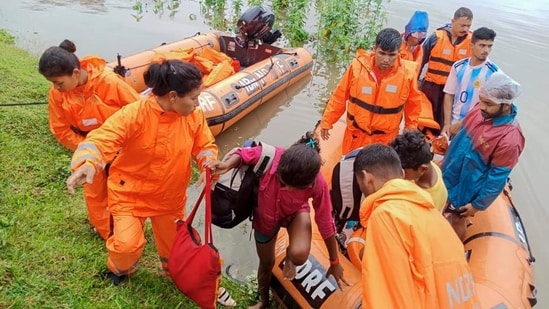 This undated photograph provided by National Disaster Response Force (NDRF) shows NDRF personnel rescuing flood affected people in north eastern Assam state. (NDRF via AP)