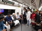Prime Minister Narendra Modi engaging with fellow passengers during his metro ride to reach Delhi University, where he attended its centenary celebrations on Friday.
