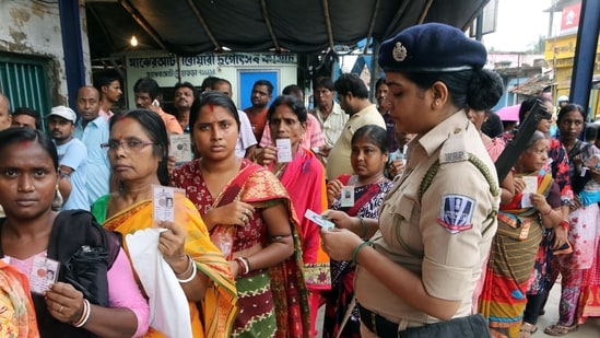 A woman Police personnel checks a voter ID card of a woman voter who arrived to cast her vote for the West Bengal Panchayat election in North 24 Parganas district on Saturday. (ANI) 