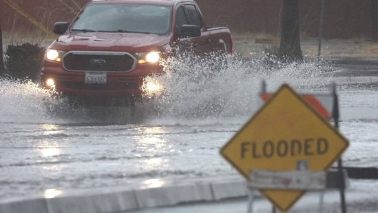 A vehicle drives through a flooded road as Tropical Storm Hilary moves through the area on August 20, 2023 in Palm Springs, California. (AFP)