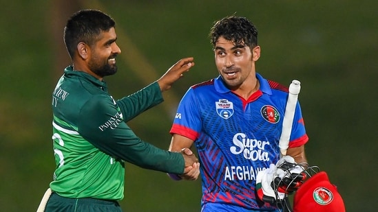 Pakistan's captain Babar Azam (L) congratulates Afghanistan's Rahmanullah Gurbaz as he walks back to the pavilion after his 151 during the 2nd ODI(AFP)