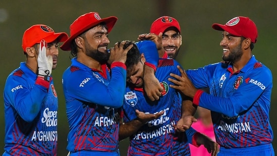 Afghanistan's Fazalhaq Farooqi (C) celebrates with teammates after the dismissal of Pakistan's captain Babar Azam(AFP)