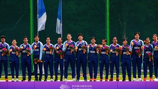 The Indian women's cricket squad on the podium with their gold medals after making history.(Getty)