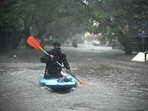 A man uses a kayak to cross a flooded street after heavy rains in Chennai on December 4, 2023. Cyclone Michuang is expected to make landfall on December 5 along the southern coast. (AFP)