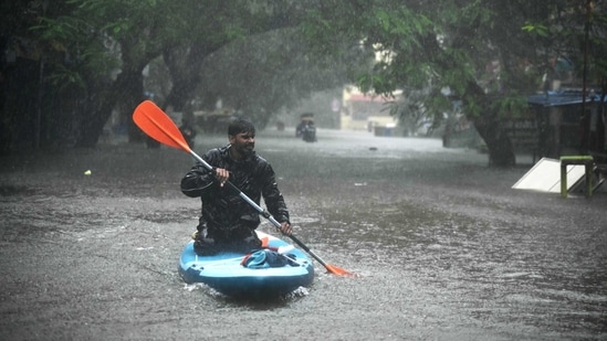 A man uses a kayak to cross a flooded street after heavy rains in Chennai on December 4, 2023. Cyclone Michuang is expected to make landfall on December 5 along the southern coast. (AFP)