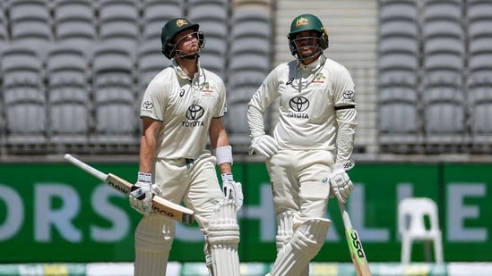 Steve Smith (L) and teammate Usman Khawaja wait for an LBW decision against Smith on day four of the first Test cricket match between Australia and Pakistan in Perth(AFP)