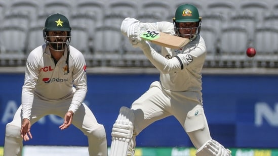 Usman Khawaja (R) plays a shot as Pakistan's Agha Salman looks on on day four of the first Test cricket match between Australia and Pakistan in Perth(AFP)