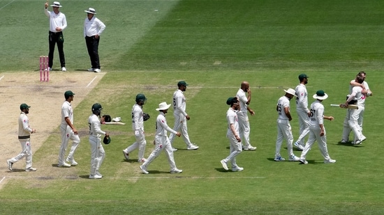 Australia's David Warner, second right, is hugged by teammate Marnus Labuschagne while Pakistan players arrive to congratulate Warner as he walks off the field after he lost his wicket on the fourth day of their cricket test match in Sydney, Saturday(AP)