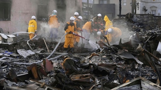 White smoke rises as firefighters work amid the wreckage from a fire at a burnt market in Wajima, Ishikawa prefecture, Japan Saturday, Jan. 6, 2024. A series of powerful quakes set off a large fire in the town of Wajima, as well as tsunamis and landslides in the region. (Kyodo News via AP)(AP)