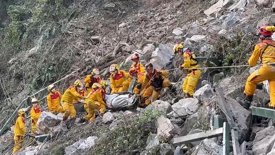 Firefighters evacuate a body from the Taroko National Park a day after a powerful earthquake struck, in the Hualien county, eastern Taiwan.(AP)