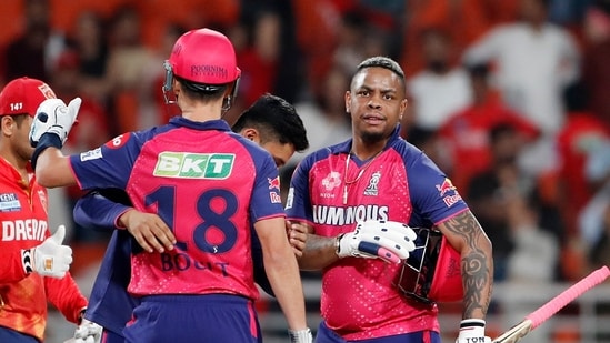 Rajasthan Royals' Shimron Hetmyer and Trent Boult greet the players after their victory against Punjab Kings.