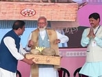 Prime Minister Narendra Modi tries his hands on playing a traditional instrument during a public meeting in support of Asom Gana Parishad (AGP) candidate Phani Bhusan Choudhury for the upcoming Lok Sabha polls in Nalbari on Wednesday.(ANI)
