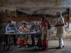 A polling official checks the name of a woman before letting her vote during the third phase of voting in Agra, Uttar Pradesh(AP)