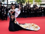 Aishwarya Rai posed for photographers at the premiere of the film Megalopolis at the 77th Cannes Film Festival. She attended the red carpet of the event in a black and gold gown adorned with intricate golden patterns. Her attire, designed by Falguni and Shane, featured a long train embellished with opulent golden flowers.(AFP)