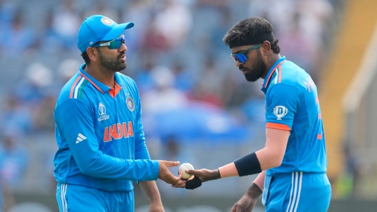 India's Hardik Pandya, right, hands the ball to captain Rohit Sharma during the ICC Men's Cricket World Cup match against Bangladesh in Pune(AP)