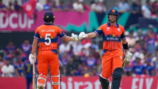 Netherlands' Max O'Dowd, right, bumps gloves with teammate Bas de Leede during their partnership against Nepal at an ICC Men's T20 World Cup cricket match(AP)