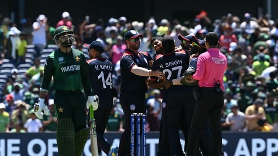 USA's players celebrate after winning the game in a super over as Pakistan's Shadab Khan walks off during the ICC men's Twenty20 World Cup 2024 group A cricket match between the USA and Pakistan at the Grand Prairie Cricket Stadium in Grand Prairie, Texas, on June 6, 2024. (Photo by ANDREW CABALLERO-REYNOLDS / AFP)(AFP)