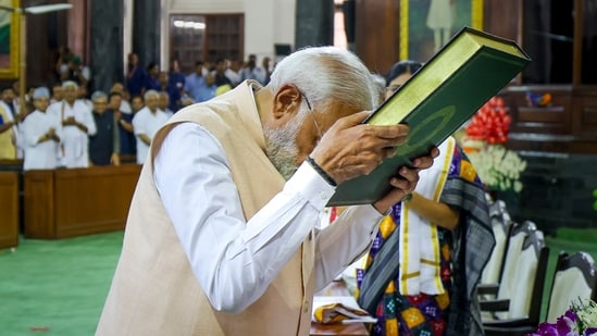Prime Minister Narendra Modi pays respects to the Constitution of India as he attends the NDA Parliamentary Party meeting at Samvidhan Sadan, in New Delhi, Friday(PTI)
