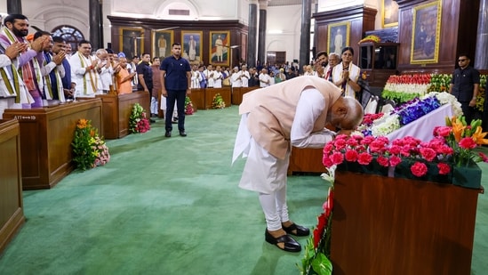 Prime Minister Narendra Modi pays respect to the Constitution of India by touching the copy with his forehead as he arrives for the National Democratic Alliance (NDA) Parliamentary Party meeting, at the Samvidhan Sadan, in New Delhi on Friday.(BJP)
