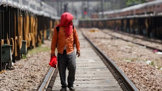 A man covers his face using a cloth to shield himself from the sun as he inspects railway tracks during a hot summer day in New Delhi. (REUTERS)(HT_PRINT)