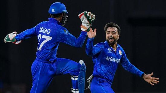 Afghanistan's captain Rashid Khan (R) and Afghanistan's Mohammad Ishaq celebrate the dismissal of Bangladesh's Rishad Hossain during the ICC men's Twenty20 World Cup 2024 Super Eight cricket match between Afghanistan and Bangladesh at Arnos Vale Stadium in Arnos Vale, Saint Vincent and the Grenadines on June 24, 2024. (Photo by Randy Brooks / AFP) (AFP)