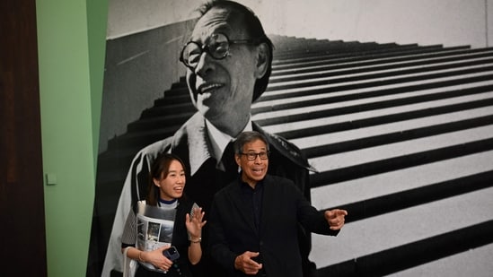 Sandi Pei (R), son of renowned Chinese-American architect I.M. Pei, is photographed in front of a photo of his father after a media preview of "I. M. Pei: Life Is Architecture", the first full-scale retrospective of I. M. Pei (1917-2019), one of the most influential architects of the twentieth and twenty-first centuries at the M+ art museum in Hong Kong.(AFP)