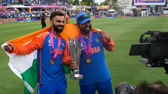 India's Virat Kohli, left, and captain Rohit Sharma pose with the winners trophy after defeating South Africa in the final(PTI)