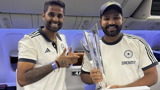 India's captain Rohit Sharma and Suryakumar Yadav pose with the ICC Men's T20 cricket World Cup 2024 trophy aboard a flight(PTI)