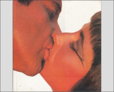 A man and woman kissing each other on the cover of a magazine in a photograph by Bert Stern