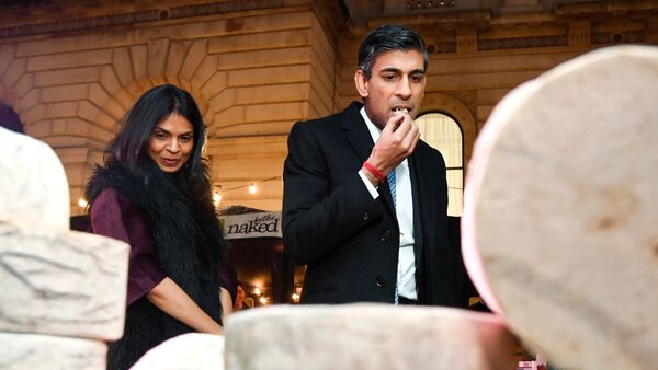 Britain's Prime Minister Rishi Sunak samples a cheese next to his wife Akshata Murty as they visit a food and drinks market promoting British small businesses at Downing Street in London (File photo)