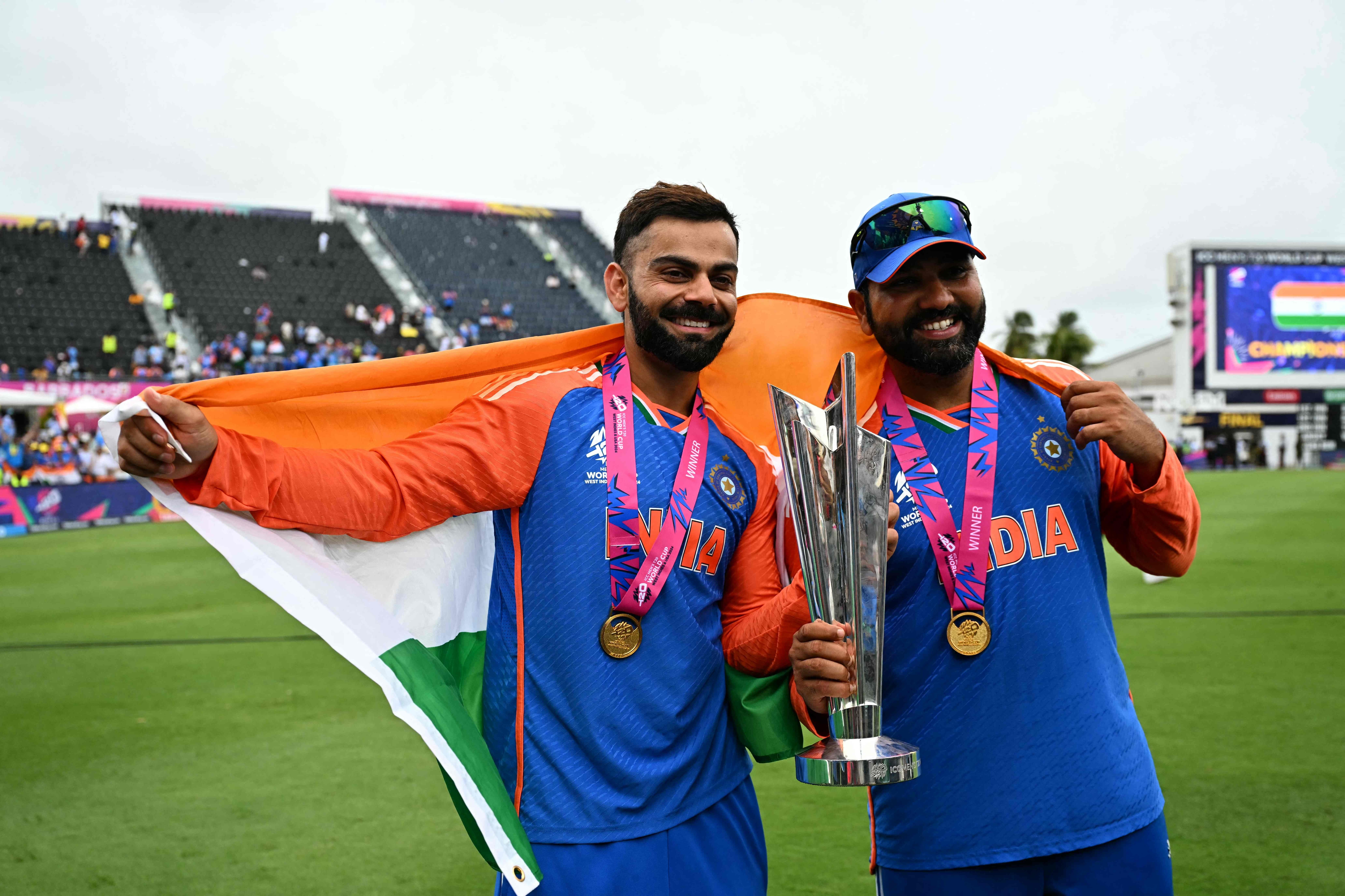 Virat Kohli and Rohit Sharma posing alongside the T20 World Cup 2024 trophy with Indian flag wrapped around them. Both of these players announced their retirement form International T20 cricket on Saturday. (AFP)